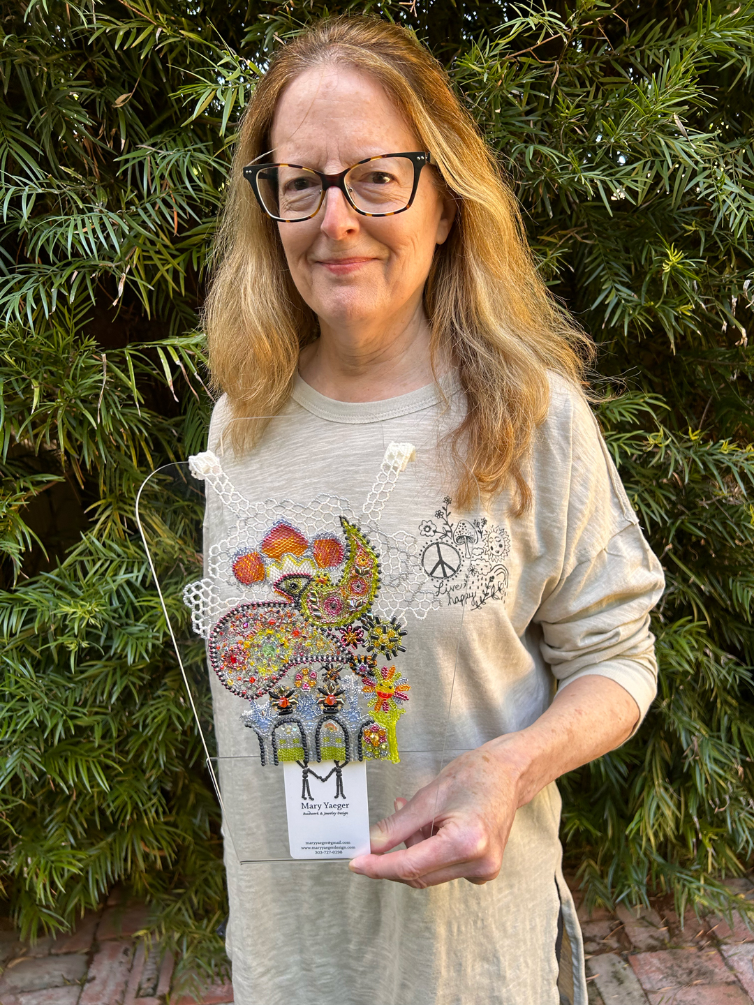 Mary Yaeger holding Circular Circulation, her designer's beadwork for the 2024 Toho Challenge.